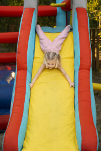 full-shot-girl-sliding-bounce-house